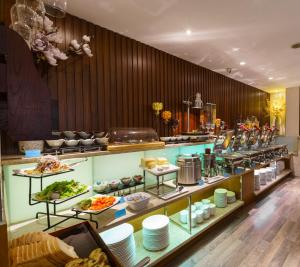 a buffet line with food on display in a restaurant at Roseland Corp Hotel in Ho Chi Minh City