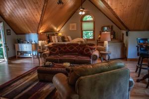 a living room with a couch and a bed at Treetop Hideaway at Barr5 Ranch in Dunlap