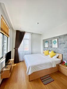 a bedroom with a large bed and a television at Quy Nhơn Balahouse in Quy Nhon