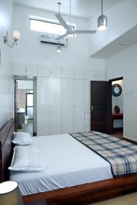 sypialnia z dużym łóżkiem i białymi ścianami w obiekcie Agosto @Aansav Verde Fatrade Varca GOA 3 BR Villa w mieście Varca