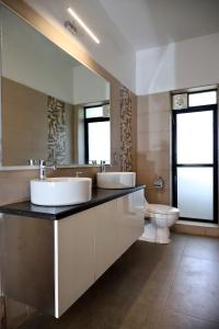 łazienka z 2 umywalkami i toaletą w obiekcie Agosto @Aansav Verde Fatrade Varca GOA 3 BR Villa w mieście Varca