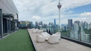 a row of white chairs sitting on top of a building at Majestic Apartment KLCC in Kuala Lumpur
