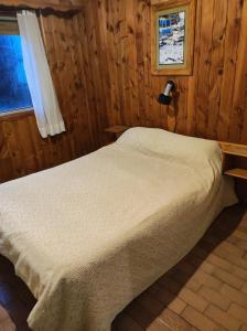 1 dormitorio con 1 cama en una habitación de madera en Hotel Panoramico Bariloche en San Carlos de Bariloche
