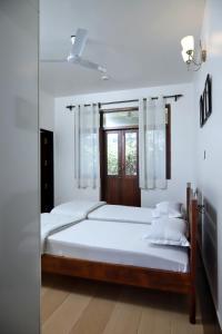 a bedroom with two beds and a window at Agosto @Aansav Verde Fatrade Varca GOA 3 BR Villa in Varca