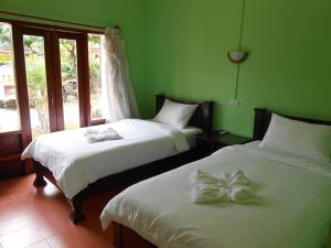 - 2 lits dans une chambre aux murs verts dans l'établissement Pongkham Residence, à Luang Prabang