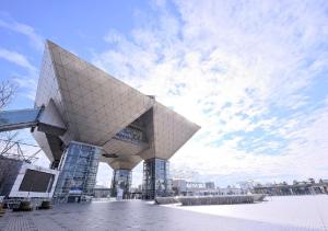 a large building with a pointed roof in a city at Tokyo Bay Ariake Washington Hotel in Tokyo