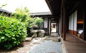 un jardín con una estatua de piedra frente a un edificio en NIPPONIA HARIMA FUKUSAKI ZOUSHONO YAKATA, en Fukusaki