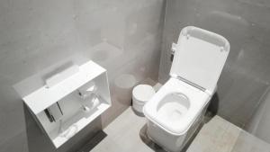 a bathroom with a white toilet and a sink at The Mangrovetree Sanya Resort in Sanya