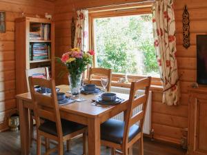 a dining room table with a vase of flowers on it at South Lodge in Great Moulton