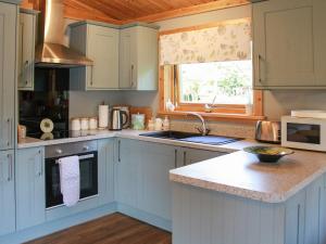 a kitchen with blue cabinets and a sink and a window at South Lodge in Great Moulton