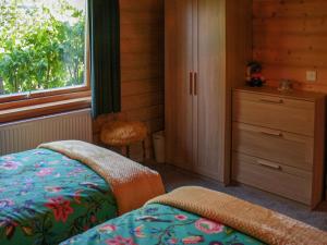 a bedroom with a bed and a dresser and a window at South Lodge in Great Moulton