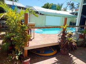 a swimming pool with a bench and some plants at Okoy Guest House in Bantayan Island