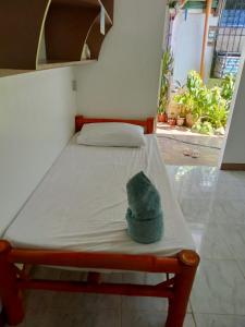 Una cama con un sombrero encima. en Okoy Guest House, en Bantayan Island