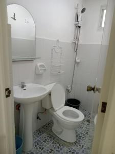 y baño con aseo blanco y lavamanos. en Okoy Guest House, en Bantayan Island