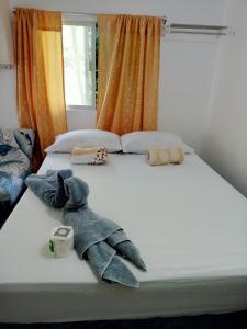una cama con dos animales de peluche sentados en ella en Okoy Guest House, en Bantayan Island
