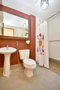 a bathroom with a toilet and a sink and a mirror at Agos Boracay Rooms + Beds in Boracay