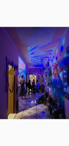 a room with purple walls and a room with people at Tebaar Backpackers in Rishīkesh