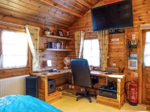 a bedroom with a desk and a computer in a cabin at Cabin Hideaways, Glengoyne - Uk38363 in Mattishall