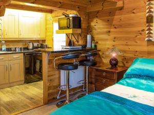 a bedroom with a bed and a kitchen in a cabin at Cabin Hideaways, Glengoyne - Uk38363 in Mattishall