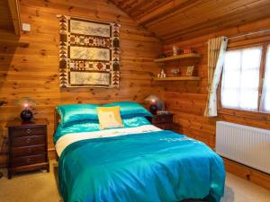 a bedroom with a bed in a log cabin at Cabin Hideaways, Glengoyne - Uk38363 in Mattishall