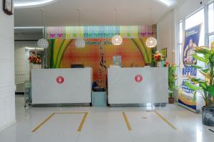 um átrio com duas mesas de recepção num edifício em Hotel Sampurna Jaya em Tanjung Pinang