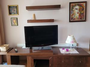 a television on a wooden desk with a lamp at Soleil Central Apartments in Skopje