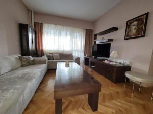 sala de estar con sofá y mesa de centro en Soleil Central Apartments, en Skopje