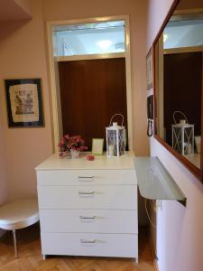 a bathroom with a white dresser and a mirror at Soleil Central Apartments in Skopje