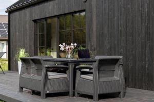 a table with two chairs and a laptop on a patio at Saunaga puhkemaja Spithamis, 250 meetrit merest! in Spithami