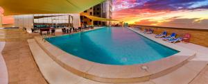 a large swimming pool on top of a building at Luxe Grand Hotel Apartments in Sharjah