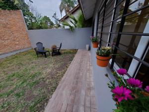 un porche de una casa con un banco y flores en Casa Azcuénaga - Parque - Zona comercial - Aerop 15 min en Monte Grande