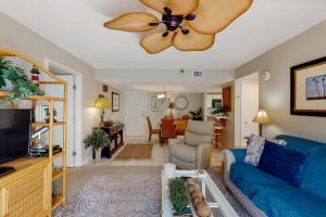 a living room with a blue couch and a ceiling fan at Peaceful Ocean Retreat in East End