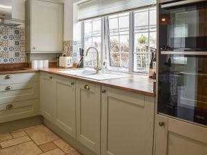 cocina con fregadero y ventana en Old Road Cottage, en Conwy