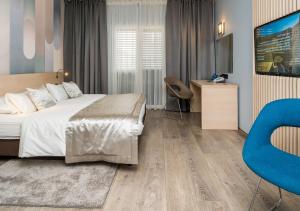 a bedroom with a large bed and a blue chair at Berkeley Hotel & Day Spa in Dubrovnik