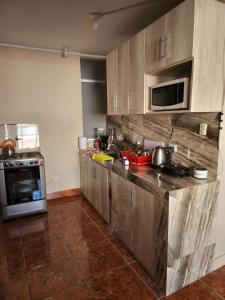 cocina con armarios de madera y encimera en Departamento Amoblado Arequipa en Arequipa