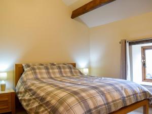 a bedroom with a bed and a window at 2 The Calf Pens in Stannington