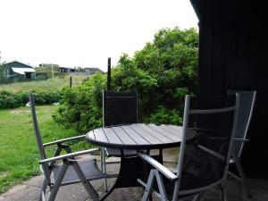 uma mesa de madeira e duas cadeiras sentadas ao lado de uma mesa e duas em 4 person holiday home in Blokhus em Blokhus