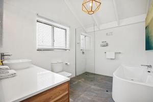 a white bathroom with a tub and a sink at The Terraces Main Beach in Byron Bay +104 photos