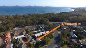 an aerial view of a house with the ocean in the background at 1 - 4 Bowral St Hawks Nest in Hawks Nest