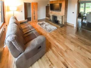 a living room with a couch and a fireplace at Hilbre in Strachur