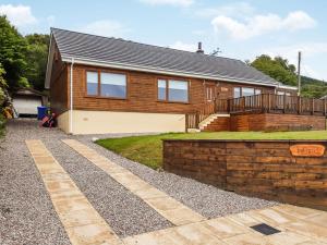 a house with a brick fence in front of it at Hilbre in Strachur