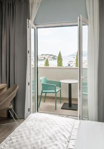 a bedroom with a bed and a chair and a table at Berkeley Hotel & Day Spa in Dubrovnik