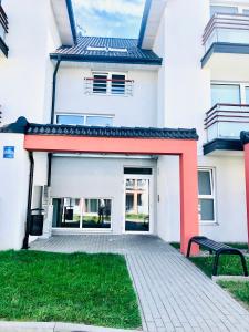 a large white building with a red roof at Syrenka apartament in Darłowo
