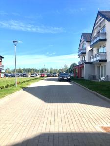 a car parked in a parking lot next to a building at Syrenka apartament in Darłowo