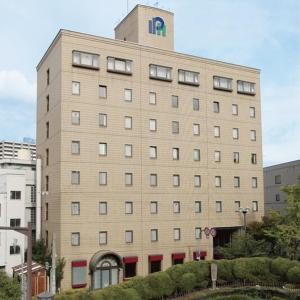a large building with a sign on the top of it at Hotel Aston Hotel Osaka Sakai in Sakai