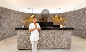 a woman standing in front of a counter in a restaurant at Royal Zanzibar Beach Resort in Nungwi