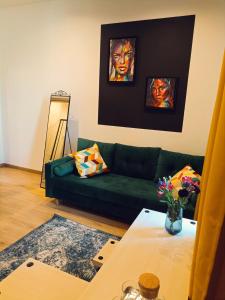 - un salon avec un canapé vert et une table dans l'établissement Apartamenty Zakładowa, à Paczków