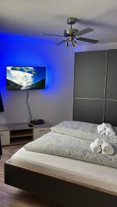 um quarto azul com uma cama e uma ventoinha de tecto em Ferienwohnung Artemis em Hanôver