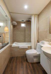 e bagno con servizi igienici, vasca e lavandino. di Golden Legend Palace Hotel a Hanoi