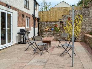 a patio with a table and chairs and a grill at Town Foot Farm in Newby